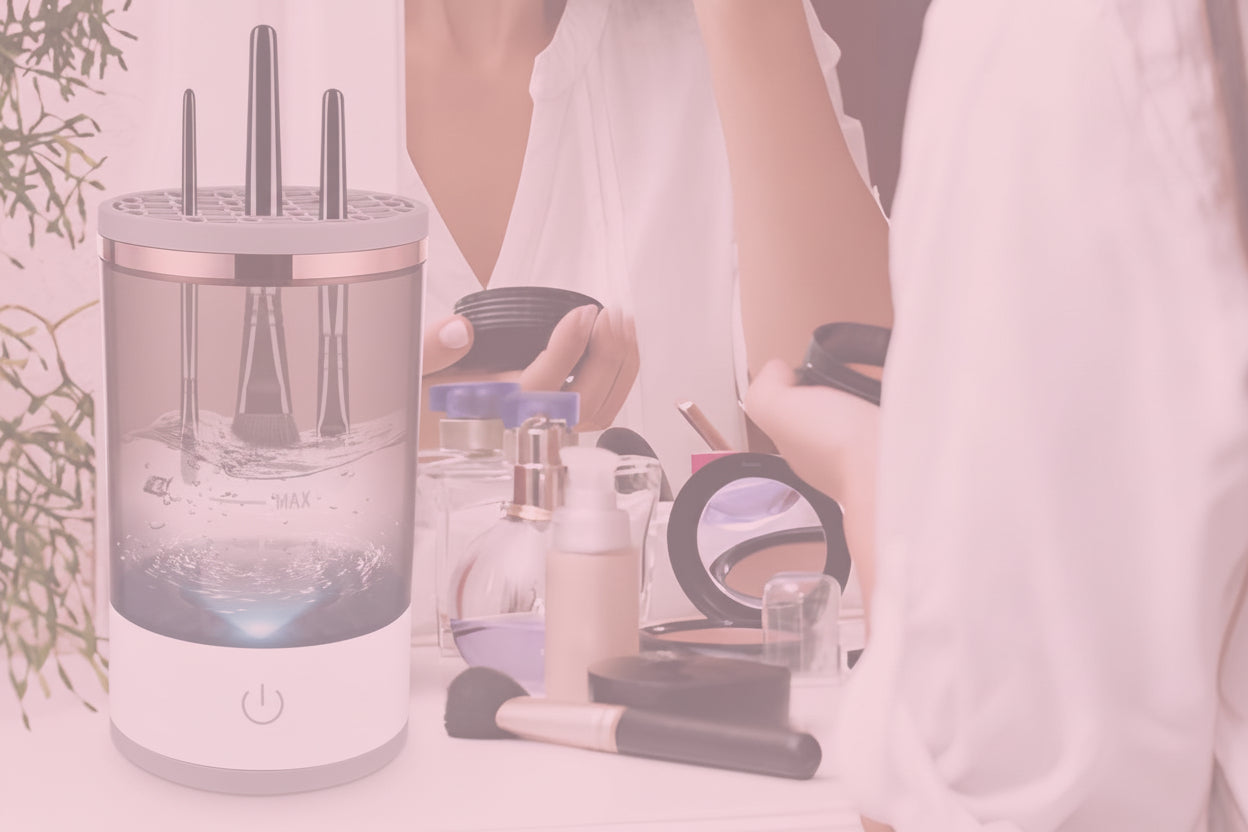 Electric makeup brush cleaner on a vanity table with a woman looking at herself in the mirror.